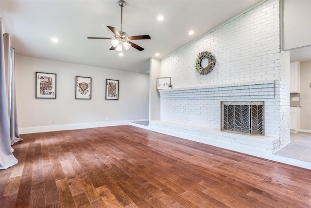 605 Sevilla Dr, Garland, TX 75043 - unfurnished living room featuring wood finished floors, ceiling fan, lofted ceiling, brick wall, and baseboards