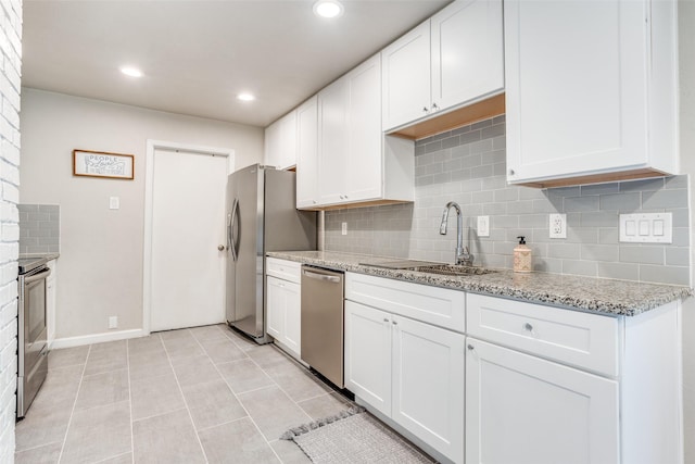 605 Sevilla Dr, Garland, TX 75043 - kitchen with appliances with stainless steel finishes, a sink, backsplash, white cabinetry, and recessed lighting