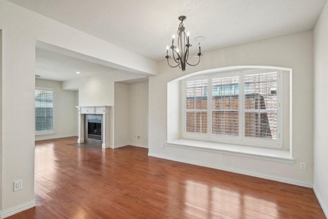 2545 Sedalia Ct, Frisco, TX 75034 - unfurnished living room featuring a chandelier, wood finished floors, baseboards, and a tiled fireplace