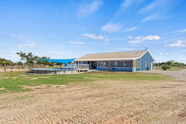 179 Johnston Dr, Decatur, TX 76234 - back of property with an outdoor pool, a sunroom, and a yard