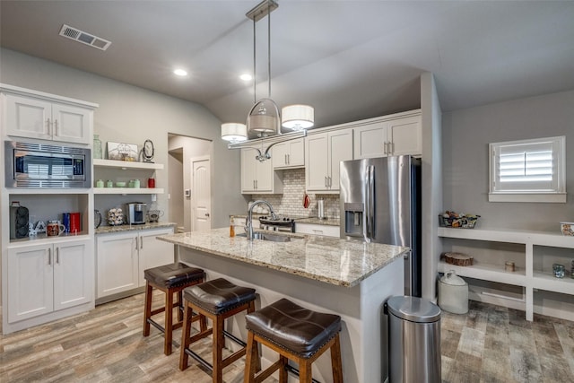 410 Phillips Ct, Mansfield, TX 76063 - kitchen featuring stainless steel appliances, light wood-type flooring, backsplash, white cabinetry, and recessed lighting