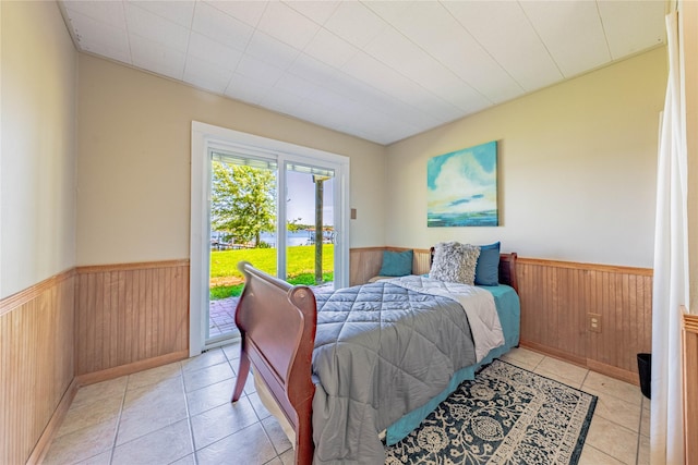 152 Pin Oak, Mabank, TX 75156 - bedroom with a wainscoted wall, access to exterior, light tile patterned flooring, and wooden walls
