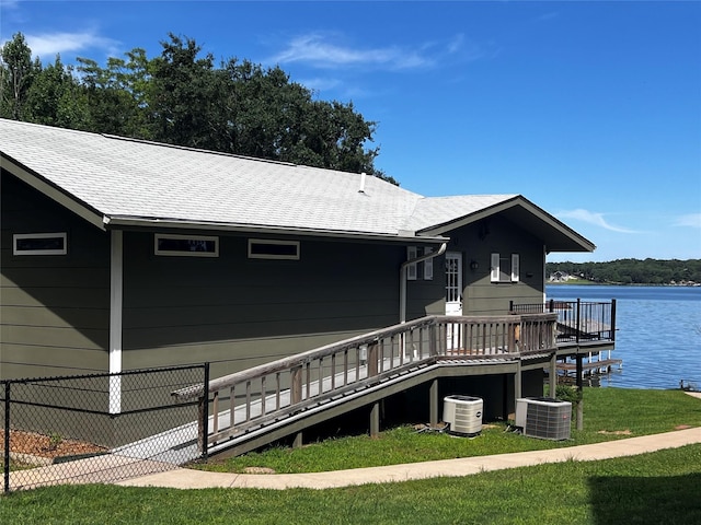 152 Pin Oak, Mabank, TX 75156 - back of house with central air condition unit, a water view, a lawn, and a shingled roof