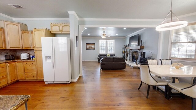1407 Lady Amber Ln, Granbury, TX 76049 - dining space with ornamental molding, light wood finished floors, a fireplace, a ceiling fan, and recessed lighting