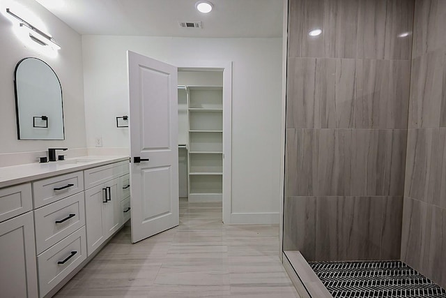 701 N Carrier Pkwy, Grand Prairie, TX 75050 - bathroom featuring vanity, a tile shower, and a walk in closet