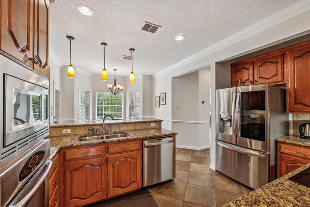 104 Lost Oaks Dr, Waco, TX 76705 - kitchen featuring appliances with stainless steel finishes, a sink, ornamental molding, a chandelier, and a textured ceiling