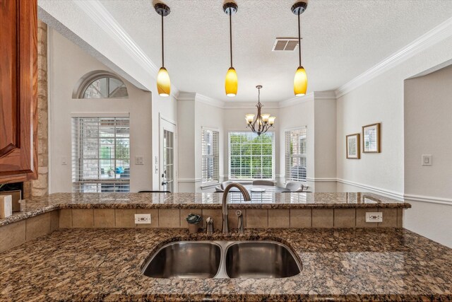 104 Lost Oaks Dr, Waco, TX 76705 - kitchen featuring a sink, dark stone countertops, crown molding, a chandelier, and decorative light fixtures