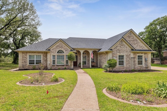 104 Lost Oaks Dr, Waco, TX 76705 - french country style house with roof with shingles, a front yard, and brick siding