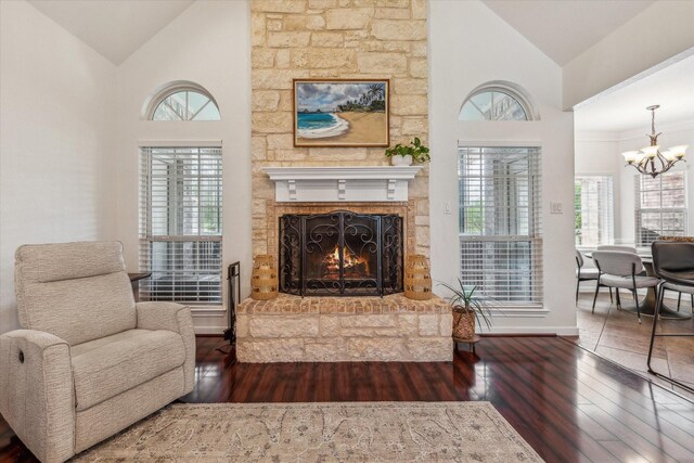 104 Lost Oaks Dr, Waco, TX 76705 - living area with a chandelier, hardwood / wood-style flooring, baseboards, high vaulted ceiling, and a warm lit fireplace