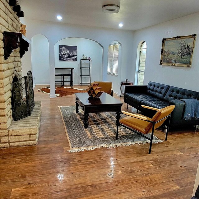15642 Overmead Cir, Dallas, TX 75248 - living area featuring arched walkways, a fireplace, wood finished floors, and recessed lighting