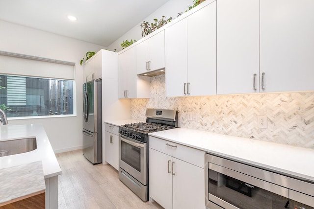 427 W 10th St Unit 803, Dallas, TX 75208 - kitchen with appliances with stainless steel finishes, a sink, light wood finished floors, light countertops, and backsplash