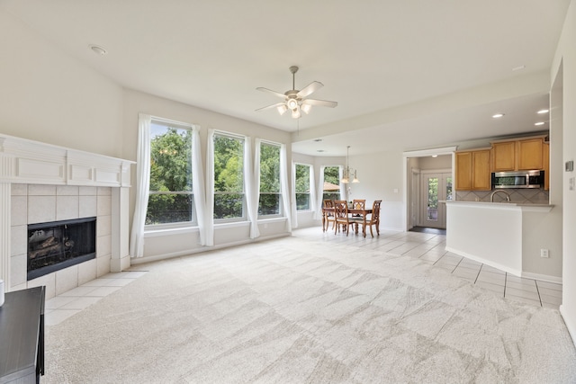 1928 Victoria Cir, Mckinney, TX 75072 - living area featuring plenty of natural light, ceiling fan, a tiled fireplace, recessed lighting, and light carpet