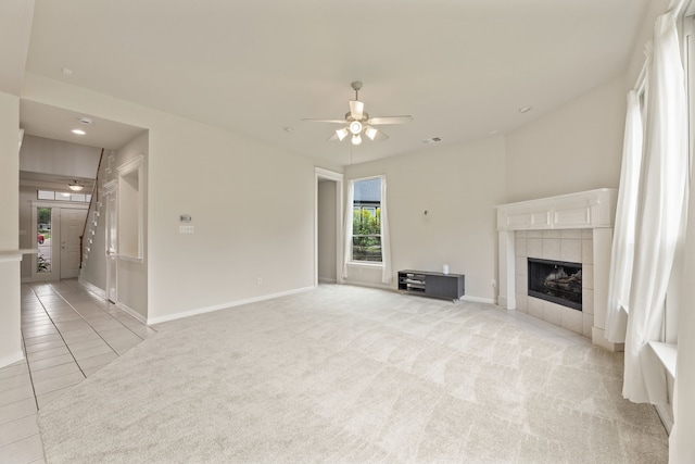1928 Victoria Cir, Mckinney, TX 75072 - unfurnished living room featuring a ceiling fan, a tiled fireplace, baseboards, light colored carpet, and light tile patterned floors