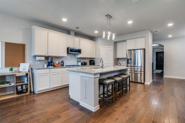 1822 Indigo Creek Ln, Wylie, TX 75098 - kitchen with stainless steel appliances, a sink, tasteful backsplash, arched walkways, and a center island with sink