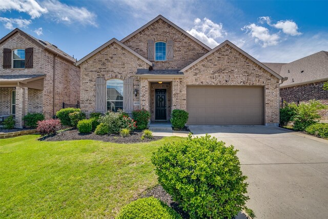 1822 Indigo Creek Ln, Wylie, TX 75098 - view of front facade featuring brick siding, concrete driveway, an attached garage, and a front lawn