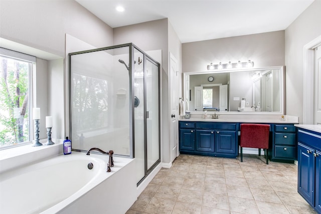 full bathroom with vanity, a shower stall, and a garden tub