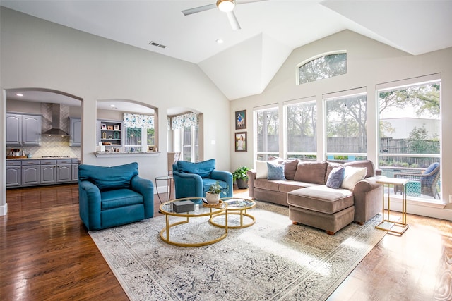 living room with dark wood-style floors, arched walkways, ceiling fan, recessed lighting, and high vaulted ceiling