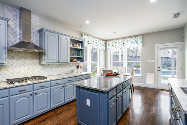 kitchen featuring wall chimney exhaust hood, blue cabinets, dark wood-style floors, tasteful backsplash, and recessed lighting