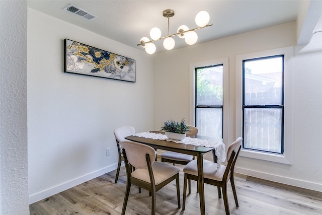 dining room featuring baseboards, a chandelier, and light wood finished floors