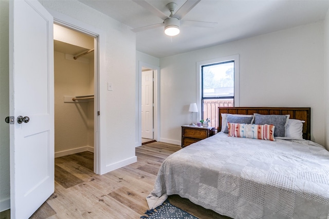 bedroom featuring light wood finished floors, baseboards, and ceiling fan