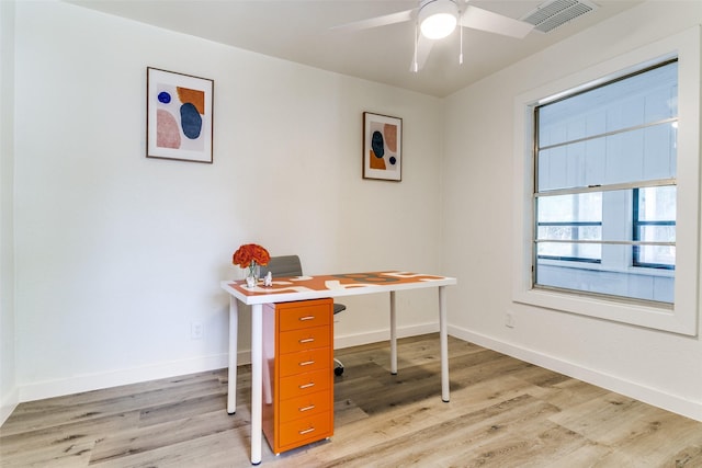 home office with light wood-style flooring, baseboards, and a ceiling fan