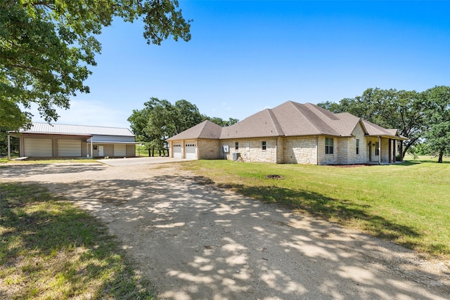 2743 Tokio Rd, West, TX 76691 - view of front of property featuring dirt driveway, a front yard, stone siding, and a garage