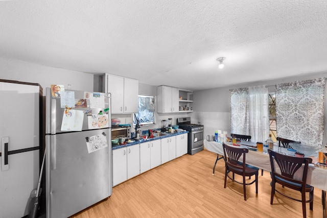 14581 Texas Highway 11 E, Pickton, TX 75471 - kitchen featuring stainless steel appliances, white cabinets, a textured ceiling, open shelves, and light wood-style floors
