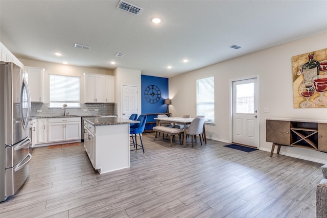 5616 Apple Grove Way, Fort Worth, TX 76123 - kitchen featuring freestanding refrigerator, a kitchen breakfast bar, a kitchen island, a sink, and white cabinetry