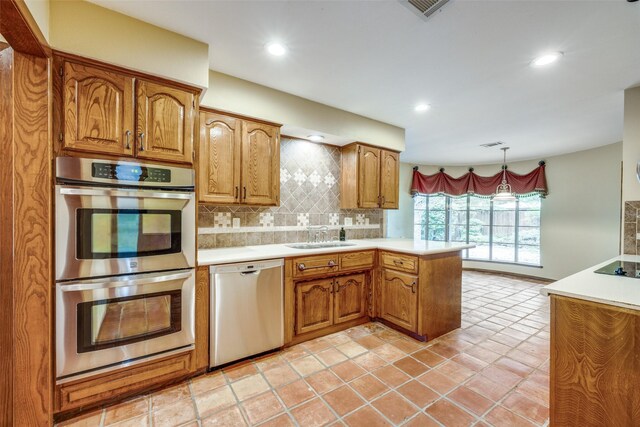 2500 Shoreline Dr, Sherman, TX 75092 - kitchen featuring stainless steel appliances, a peninsula, a sink, tasteful backsplash, and light countertops