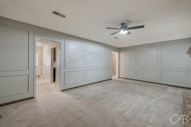 4417 Pamela Dr, Abilene, TX 79606 - unfurnished bedroom featuring a decorative wall, light carpet, ceiling fan, and a textured ceiling