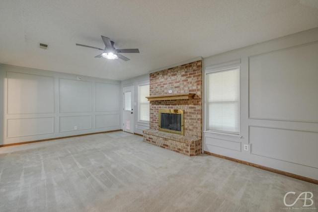 4417 Pamela Dr, Abilene, TX 79606 - unfurnished living room featuring a decorative wall, ceiling fan, plenty of natural light, carpet, and a brick fireplace