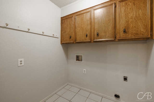 4417 Pamela Dr, Abilene, TX 79606 - laundry room with cabinet space, washer hookup, hookup for an electric dryer, baseboards, and light tile patterned floors