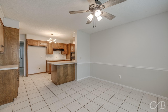 4417 Pamela Dr, Abilene, TX 79606 - kitchen featuring a peninsula, under cabinet range hood, a chandelier, light countertops, and light tile patterned flooring