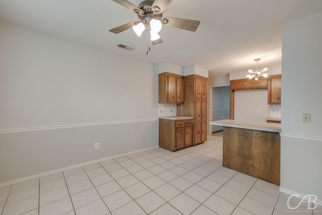 4417 Pamela Dr, Abilene, TX 79606 - kitchen featuring brown cabinets, light countertops, a chandelier, a ceiling fan, and pendant lighting