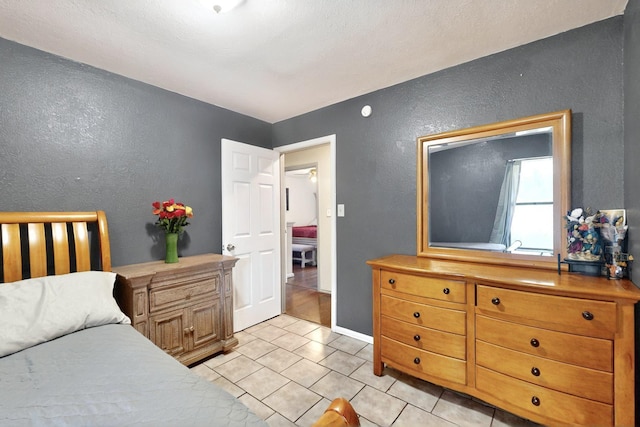 805 Loganwood Dr, Royse City, TX 75189 - bedroom with a textured wall and light tile patterned floors