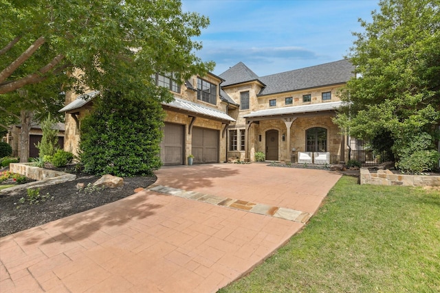 933 Glenhurst Rd, Keller, TX 76248 - view of front facade with a standing seam roof, an attached garage, driveway, stone siding, and metal roof