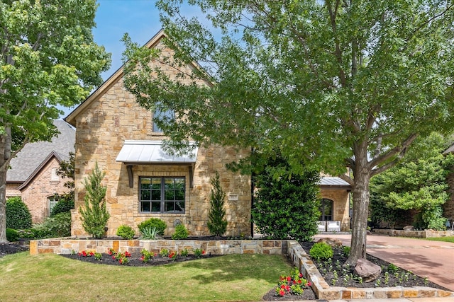 933 Glenhurst Rd, Keller, TX 76248 - view of front of house with a standing seam roof, stone siding, a front lawn, and metal roof