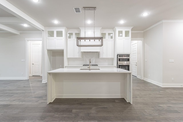 3928 Hogan Dr, Tyler, TX 75709 - kitchen featuring stainless steel double oven, a center island with sink, baseboards, decorative backsplash, and recessed lighting