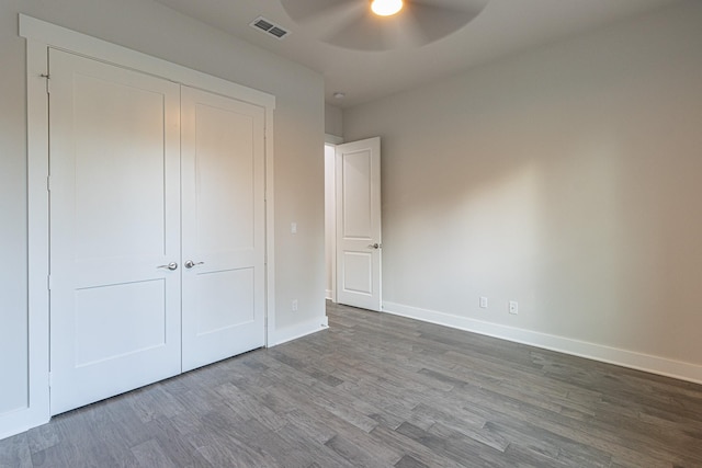 3928 Hogan Dr, Tyler, TX 75709 - unfurnished bedroom featuring dark wood-type flooring, baseboards, a closet, and a ceiling fan