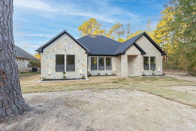 3928 Hogan Dr, Tyler, TX 75709 - french provincial home featuring stone siding, a front yard, and roof with shingles
