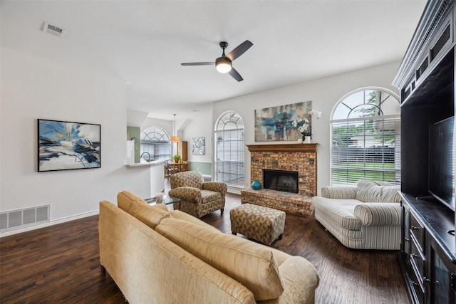 8630 Hidden Spring Dr, Frisco, TX 75034 - living area featuring dark wood-type flooring, a ceiling fan, a brick fireplace, and baseboards