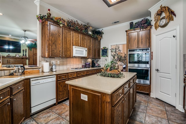 2305 Rosser Ct, Rowlett, TX 75088 - kitchen with white appliances, tasteful backsplash, ornamental molding, ceiling fan, and a kitchen island