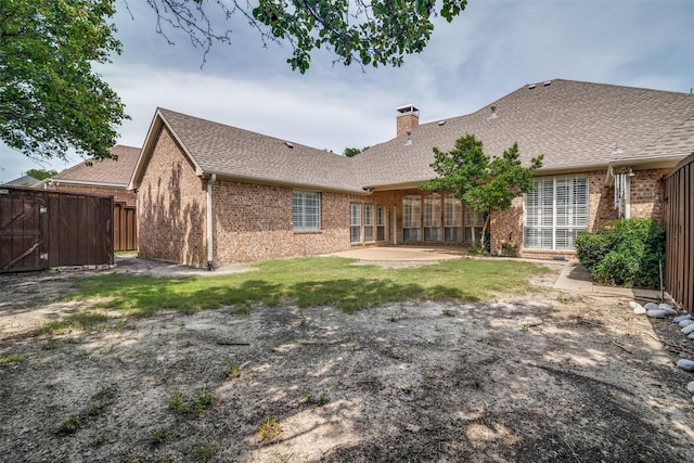 2305 Rosser Ct, Rowlett, TX 75088 - back of house featuring brick siding, a chimney, fence, and roof with shingles