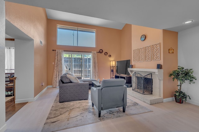 6433 Southpoint Dr, Dallas, TX 75248 - living area featuring a fireplace, wood finished floors, a towering ceiling, and baseboards