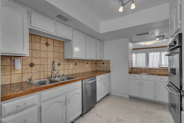 6433 Southpoint Dr, Dallas, TX 75248 - kitchen with stainless steel appliances, a sink, white cabinets, tile counters, and decorative backsplash