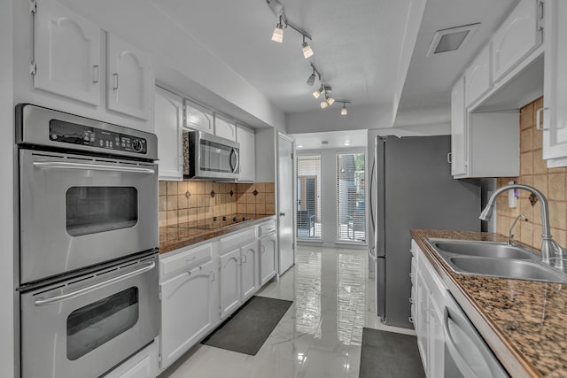 6433 Southpoint Dr, Dallas, TX 75248 - kitchen with appliances with stainless steel finishes, a sink, white cabinetry, backsplash, and dark countertops