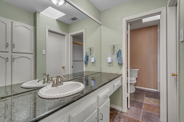 6433 Southpoint Dr, Dallas, TX 75248 - bathroom with toilet, stone tile floors, vanity, and a skylight