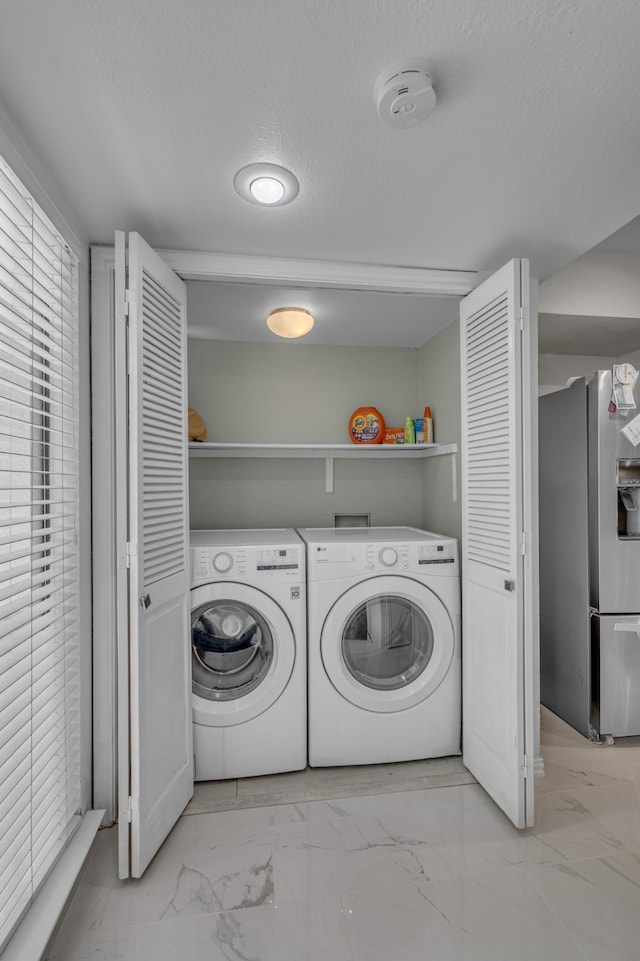 6433 Southpoint Dr, Dallas, TX 75248 - clothes washing area featuring washing machine and clothes dryer, light marble finish floors, and a textured ceiling