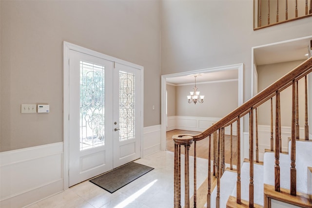 3213 Louis Dr, Plano, TX 75023 - foyer entrance featuring wainscoting, a chandelier, a decorative wall, stairs, and a towering ceiling