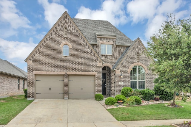 9012 Terrel St, Lantana, TX 76226 - view of front of house with brick siding, roof with shingles, a front yard, and concrete driveway